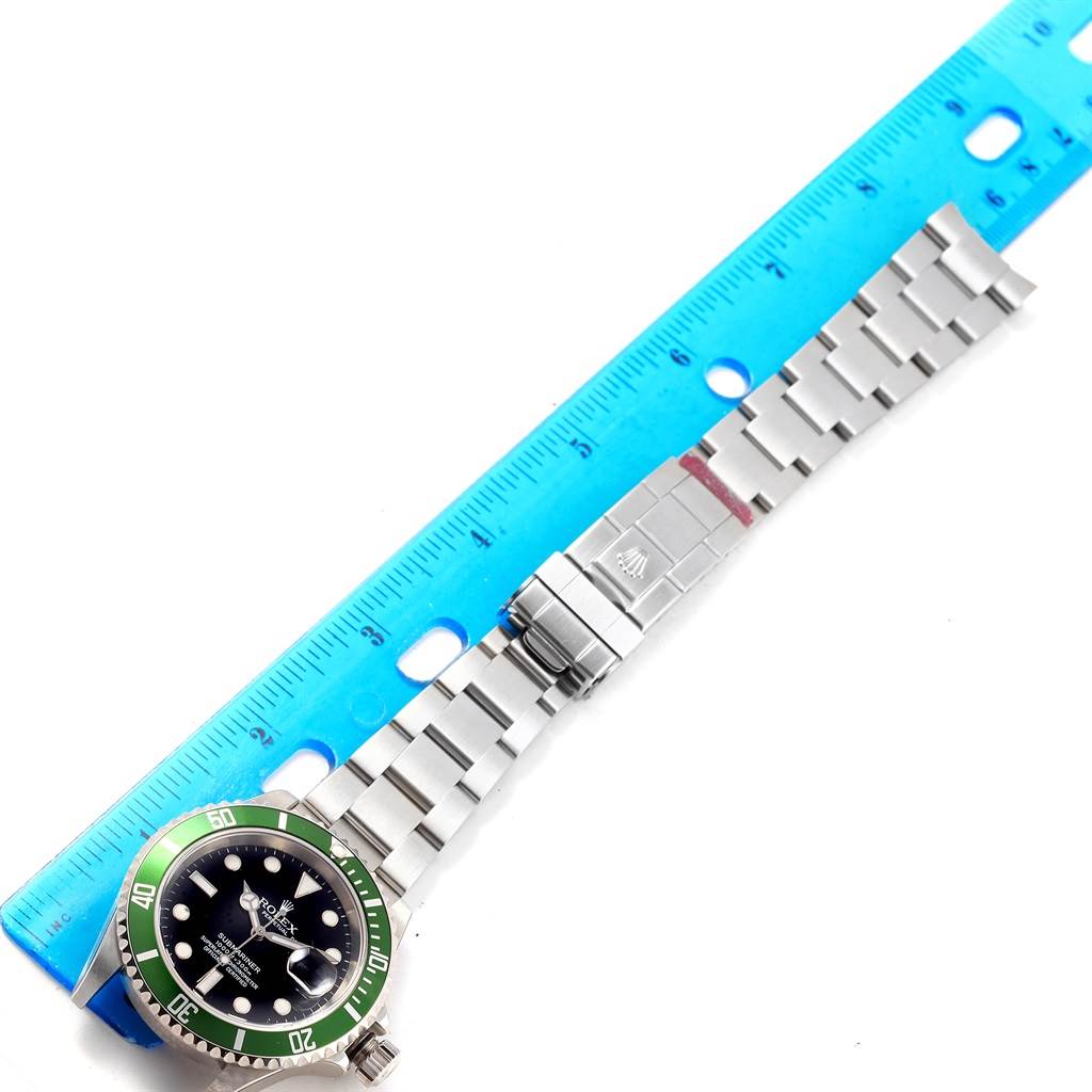 The image shows a top-down view of a Rolex Submariner 16610LV Men's Stainless Steel Black Dial 16610LV Men's Stainless Steel Black Dial watch with its metal bracelet and clasp extended next to a ruler.