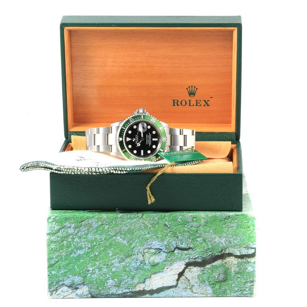 The Rolex Submariner 16610LV Men's Stainless Steel Black Dial 16610LV Men's Stainless Steel Black Dial watch is displayed frontally in an open wooden box with the brand logo visible on the inside back of the lid.