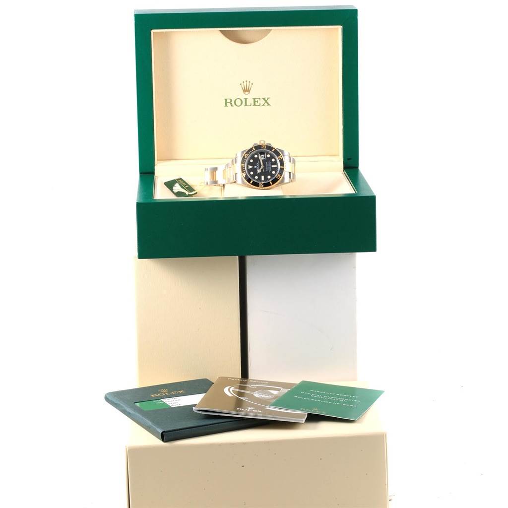 The image shows a Rolex Submariner 116613 Men's Steel and Gold (two tone) Black Dial 116613 Men's Steel and Gold (two tone) Black Dial watch in its box, along with manuals and accessories displayed in front.