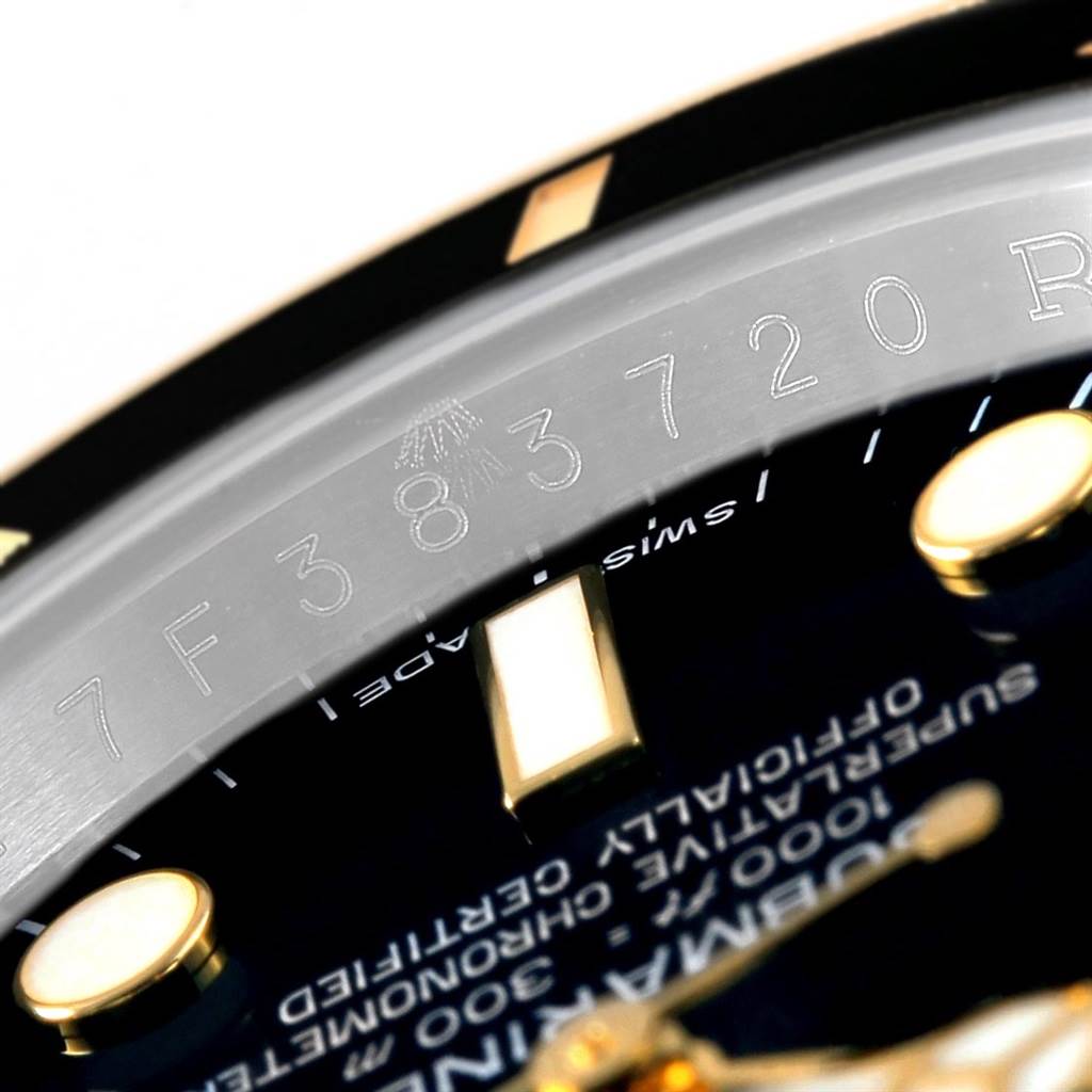 Close-up of the engraved inner bezel showing serial number and part of the dial from a Rolex Submariner 116613 Men's Steel and Gold (two tone) Black Dial 116613 Men's Steel and Gold (two tone) Black Dial watch.