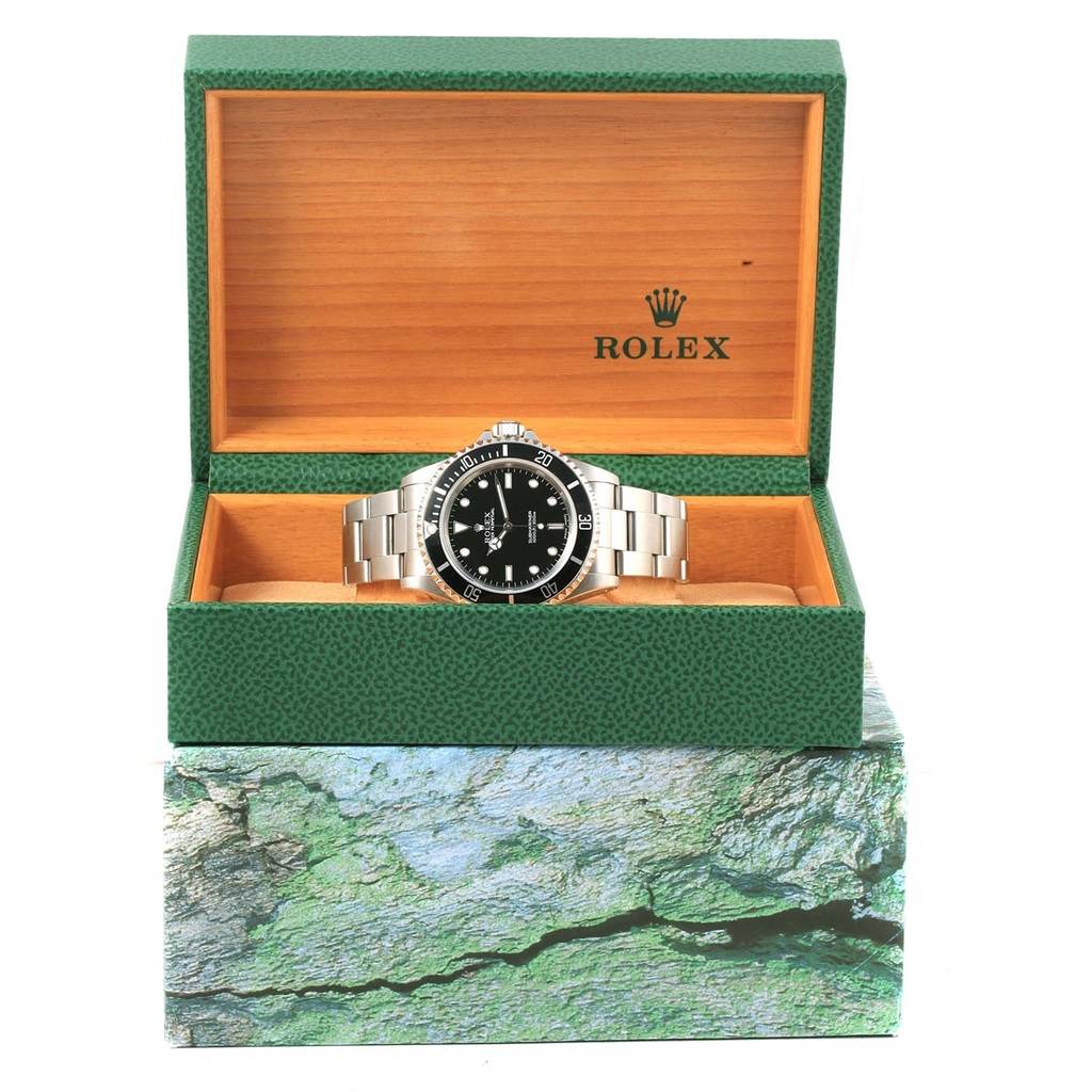 The Rolex Submariner 14060 Men's Stainless Steel Black Dial 14060 Men's Stainless Steel Black Dial watch is displayed front-facing inside an open green and wooden Rolex box.