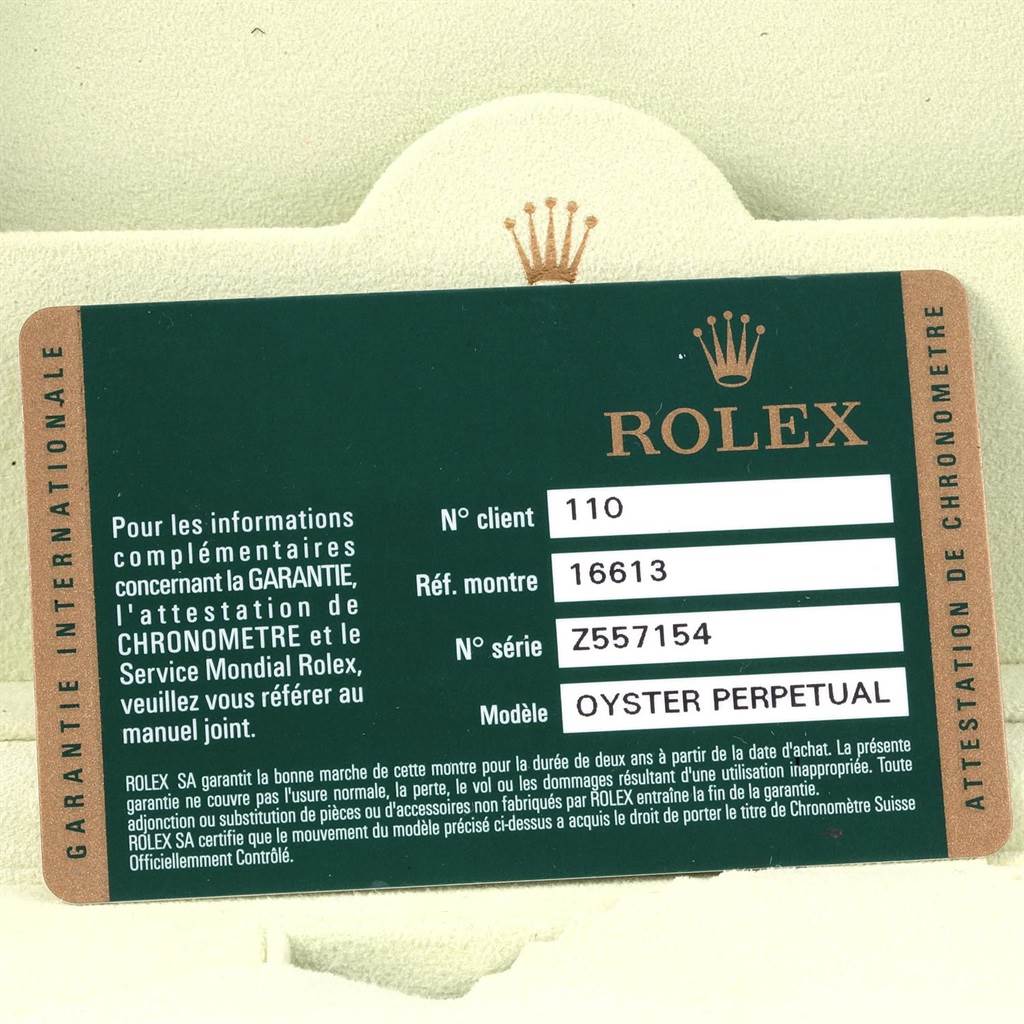The image shows a close-up of the warranty card for a Rolex Submariner 16613 Men's Steel and Gold (two tone) Blue Dial 16613 Men's Steel and Gold (two tone) Blue Dial model, including its reference and serial numbers.