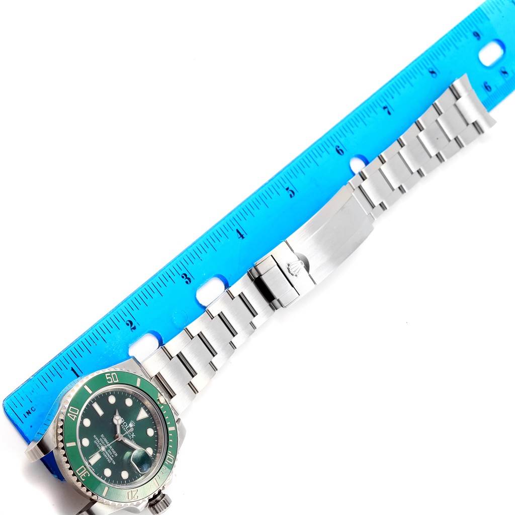 This image shows a Rolex Submariner 116610LV Men's Stainless Steel Green Dial 116610LV Men's Stainless Steel Green Dial watch with the face, bezel, and bracelet, measured against a blue ruler.