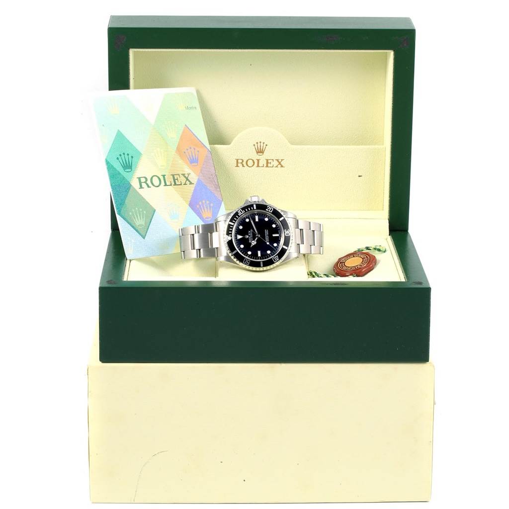 This image shows the Rolex Submariner 14060 Men's Stainless Steel Black Dial 14060 Men's Stainless Steel Black Dial watch inside its open green box with the warranty card and a tag next to it.