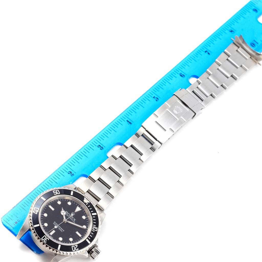 The image shows the full length of a Rolex Submariner 14060 Men's Stainless Steel Black Dial 14060 Men's Stainless Steel Black Dial watch, including the face, bezel, bracelet, and clasp, next to a ruler for scale.