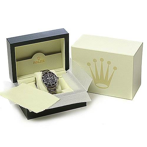 The image shows a Rolex Submariner 16610 Men's Stainless Steel Black Dial 16610 Men's Stainless Steel Black Dial watch in an open presentation box, alongside a closed box and a polishing cloth.