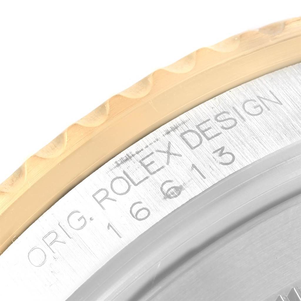 The image shows a close-up of the bezel and part of the case of a Rolex Submariner 16613 Men's Steel and Gold (two tone) Black Dial 16613 Men's Steel and Gold (two tone) Black Dial, focusing on the engraved text "ORIG. ROLEX DESIGN."