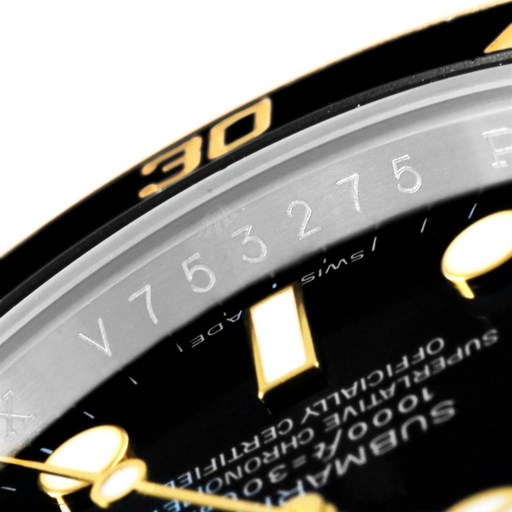 This image shows a close-up of the serial number and part of the dial on a Rolex Submariner 116613 Men's Steel and Gold (two tone) Black Dial 116613 Men's Steel and Gold (two tone) Black Dial watch.
