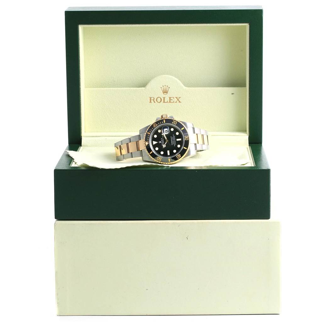 The Rolex Submariner 116613 Men's Steel and Gold (two tone) Black Dial 116613 Men's Steel and Gold (two tone) Black Dial watch is shown angled slightly to the right, displayed in an open green Rolex box.