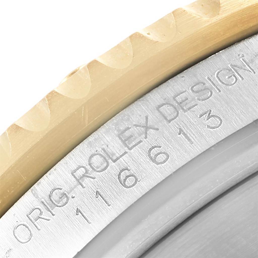 The image shows a close-up angle of the side of the bezel and case back engraving of a Rolex Submariner 116613 Men's Steel and Gold (two tone) Blue Dial 116613 Men's Steel and Gold (two tone) Blue Dial.