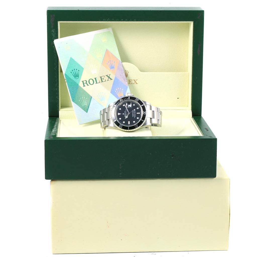 The Rolex Submariner 16610 Men's Stainless Steel Black Dial 16610 Men's Stainless Steel Black Dial watch is shown inside an open green box along with its manual.