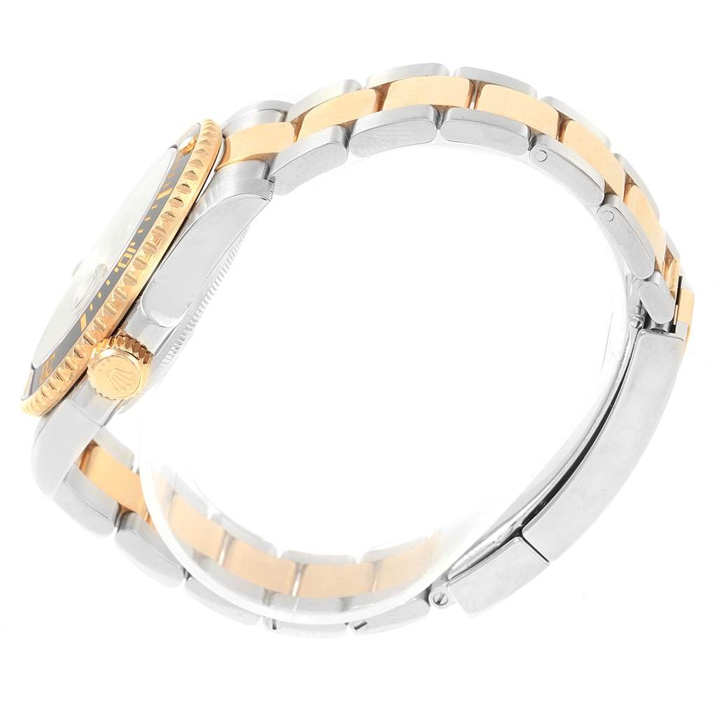 This image shows the side angle of a Rolex Submariner 116613 Men's Steel and Gold (two tone) Black Dial 116613 Men's Steel and Gold (two tone) Black Dial watch, highlighting its crown, bezel, and two-tone bracelet.