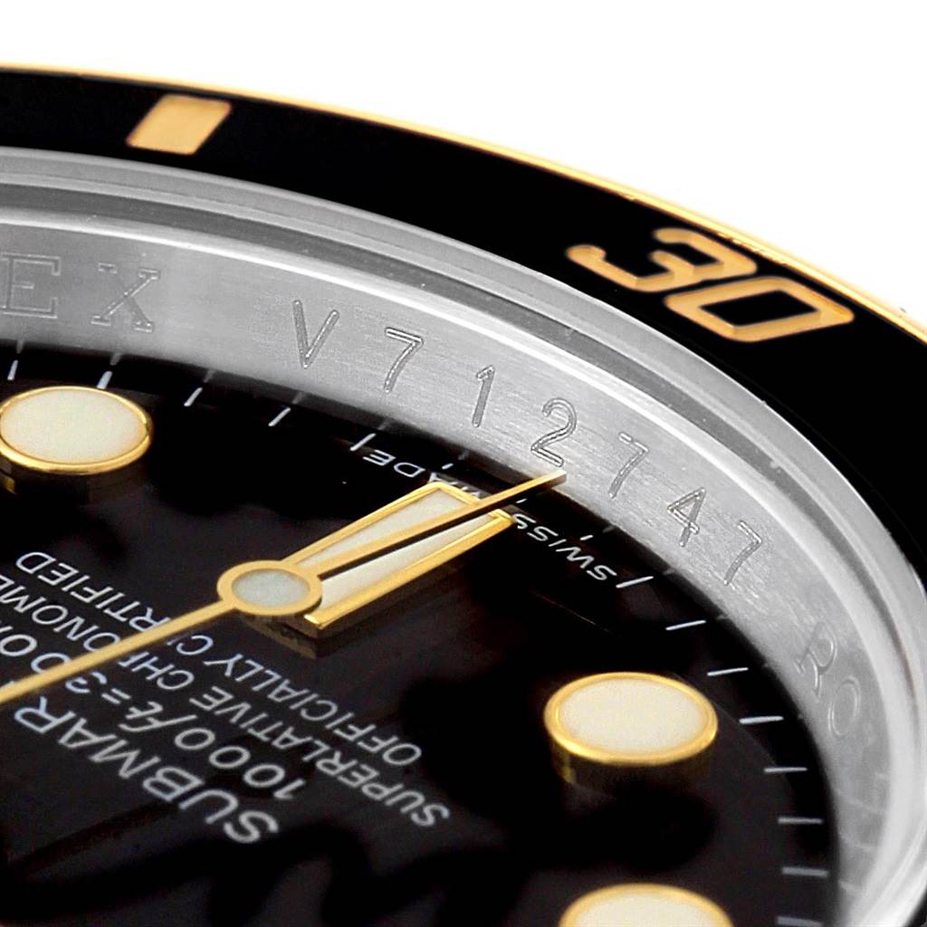 The image shows a close-up angle of the Rolex Submariner 116613 Men's Steel and Gold (two tone) Black Dial 116613 Men's Steel and Gold (two tone) Black Dial's dial and ceramic bezel with part of the reference number visible.
