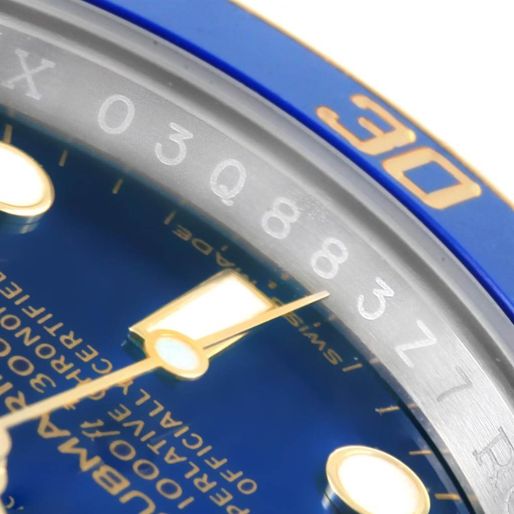 The image shows a close-up angle of the Rolex Submariner 116613 Men's Steel and Gold (two tone) Blue Dial 116613 Men's Steel and Gold (two tone) Blue Dial watch face, focusing on its blue bezel and part of the dial with numeric engravings.