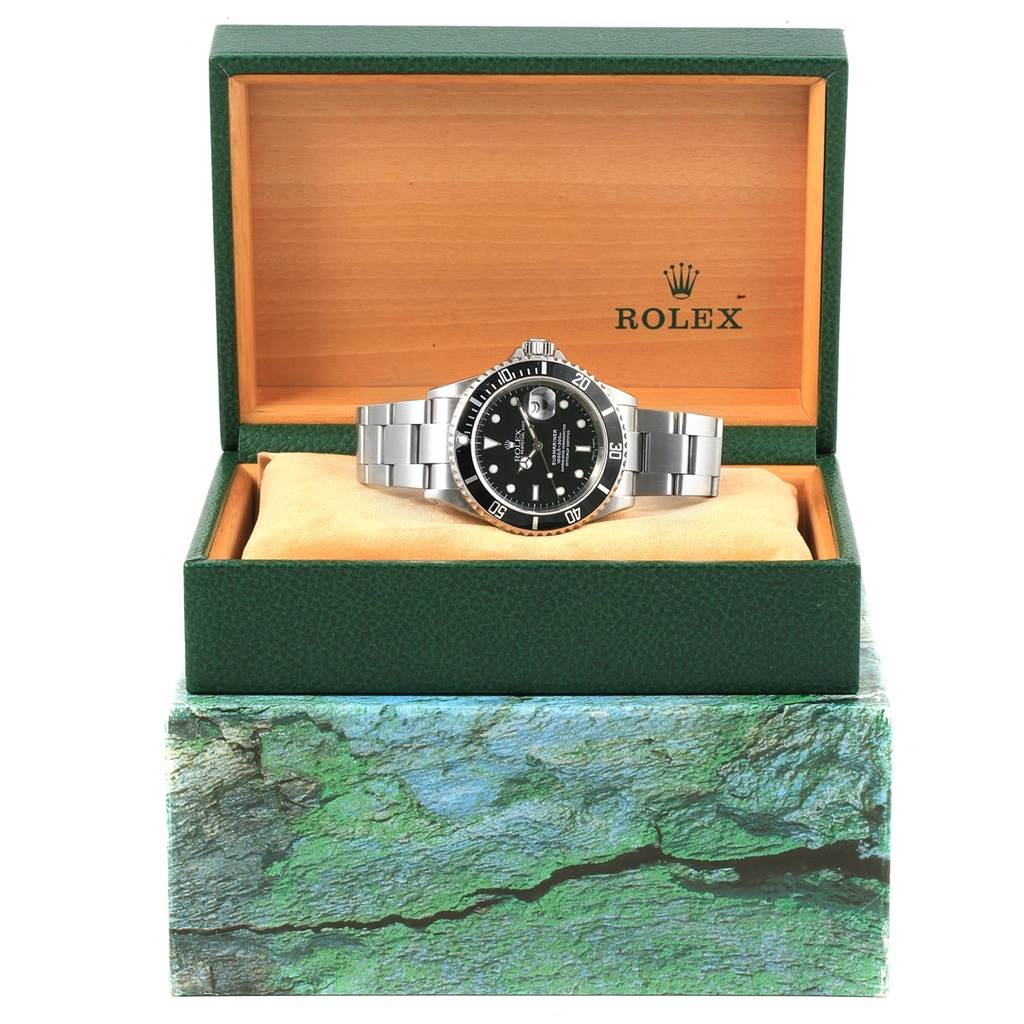 The Rolex Submariner 16610 Men's Stainless Steel Black Dial 16610 Men's Stainless Steel Black Dial watch is displayed front-on in an open box, showcasing its face, bracelet, and bezel.