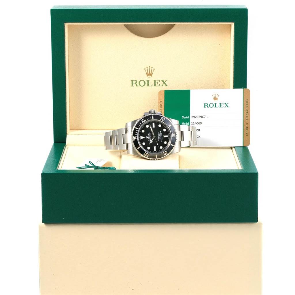 The Rolex Submariner 114060 Men's Stainless Steel Black Dial 114060 Men's Stainless Steel Black Dial watch is displayed front-facing in its box, alongside documentation and a tag.