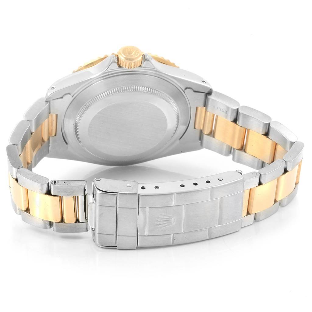 The image shows the back view of a Rolex Submariner 16613 Men's Steel and Gold (two tone) Blue Dial 16613 Men's Steel and Gold (two tone) Blue Dial watch, displaying its case, crown, and bracelet clasp.