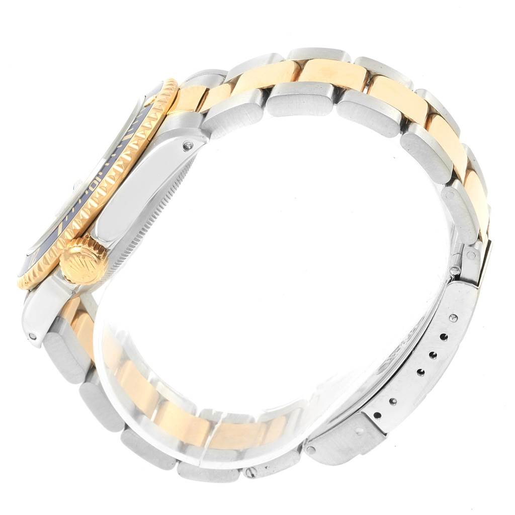 The image shows the side angle of a Rolex Submariner 16613 Men's Steel and Gold (two tone) Blue Dial 16613 Men's Steel and Gold (two tone) Blue Dial watch, highlighting the crown, bezel, and two-tone metal bracelet.