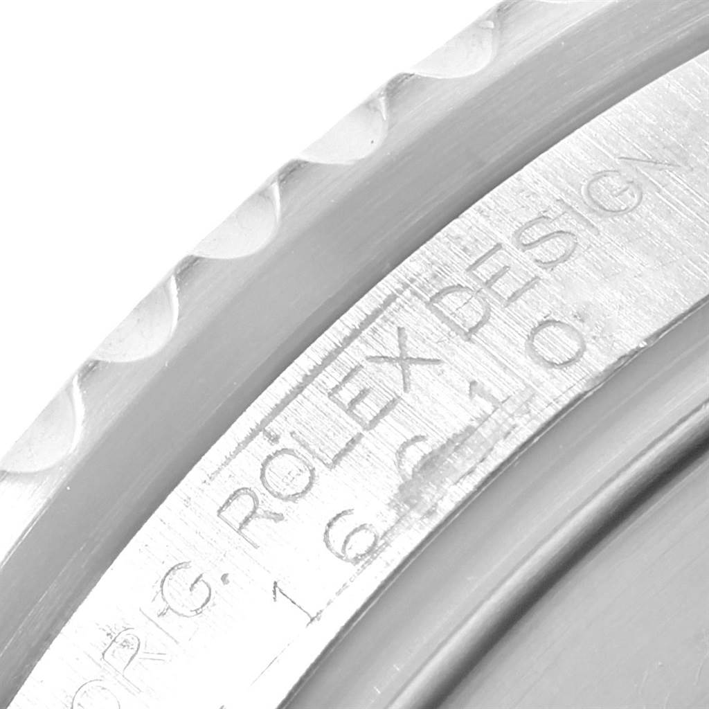 This close-up image of a Rolex Submariner 16610 Men
s Stainless Steel Black Dial 16610 Men
s Stainless Steel Black Dial shows part of the bezel and the engraved text on the edge of the case.