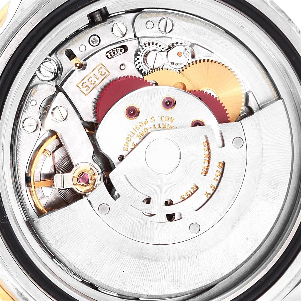 This image shows a close-up of the internal mechanism of a Rolex Submariner 16613 Men
s Steel and Gold (two tone) Blue Dial 16613 Men
s Steel and Gold (two tone) Blue Dial watch, specifically the movement and gears.