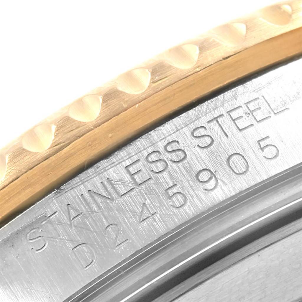 The image shows a close-up of the Rolex Submariner 16613 Men
s Steel and Gold (two tone) Blue Dial 16613 Men
s Steel and Gold (two tone) Blue Dial model
s stainless steel case back edge and part of the bezel.