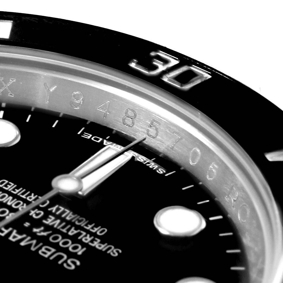 The image shows a close-up angle of a Rolex Submariner 114060 Men
s Stainless Steel Black Dial 114060 Men
s Stainless Steel Black Dial watch, highlighting the bezel, minute hand, and part of the dial with markers.