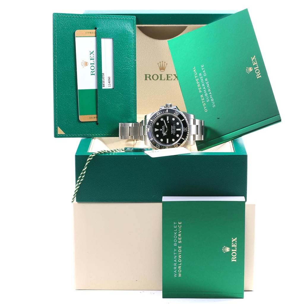 The image shows a Rolex Submariner 114060 Men
s Stainless Steel Black Dial 114060 Men
s Stainless Steel Black Dial watch with its box, warranty card, booklet, and accessories overall.