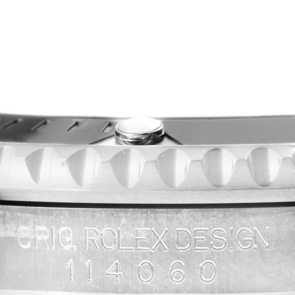 This image shows a close-up of a Rolex Submariner 114060 Men's Stainless Steel Black Dial 114060 Men's Stainless Steel Black Dial watch bezel and the model number engraved on the side.