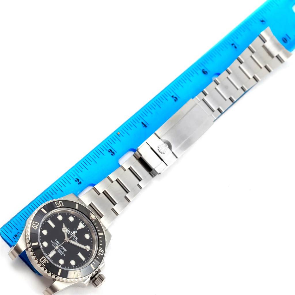 The image shows a Rolex Submariner 114060 Men's Stainless Steel Black Dial 114060 Men's Stainless Steel Black Dial watch placed next to a ruler for measurement, capturing the face and bracelet.