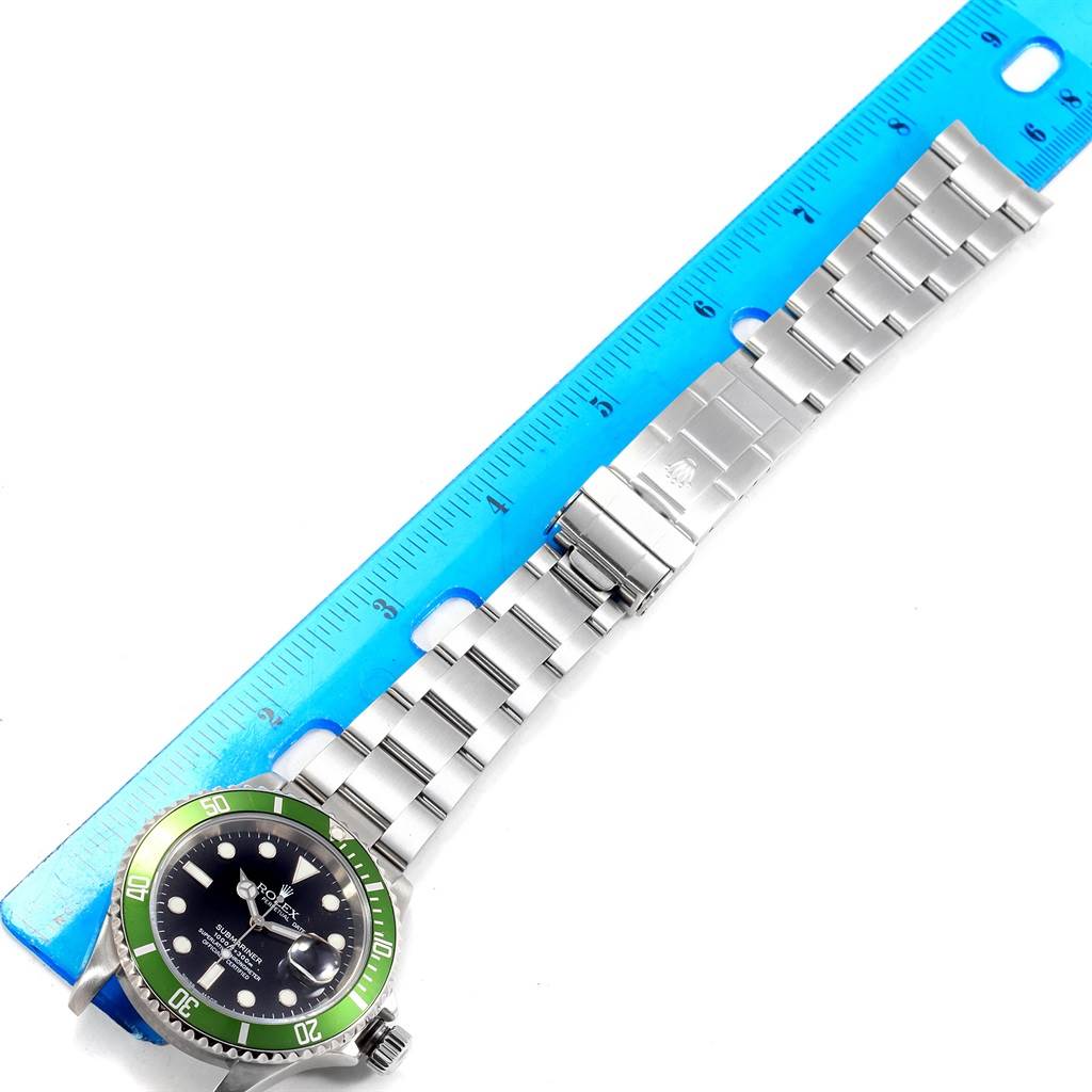 The Rolex Submariner 16610LV Men
s Stainless Steel Black Dial 16610LV Men
s Stainless Steel Black Dial watch is displayed at an angle, showing the dial, bezel, bracelet, and clasp alongside a blue ruler.