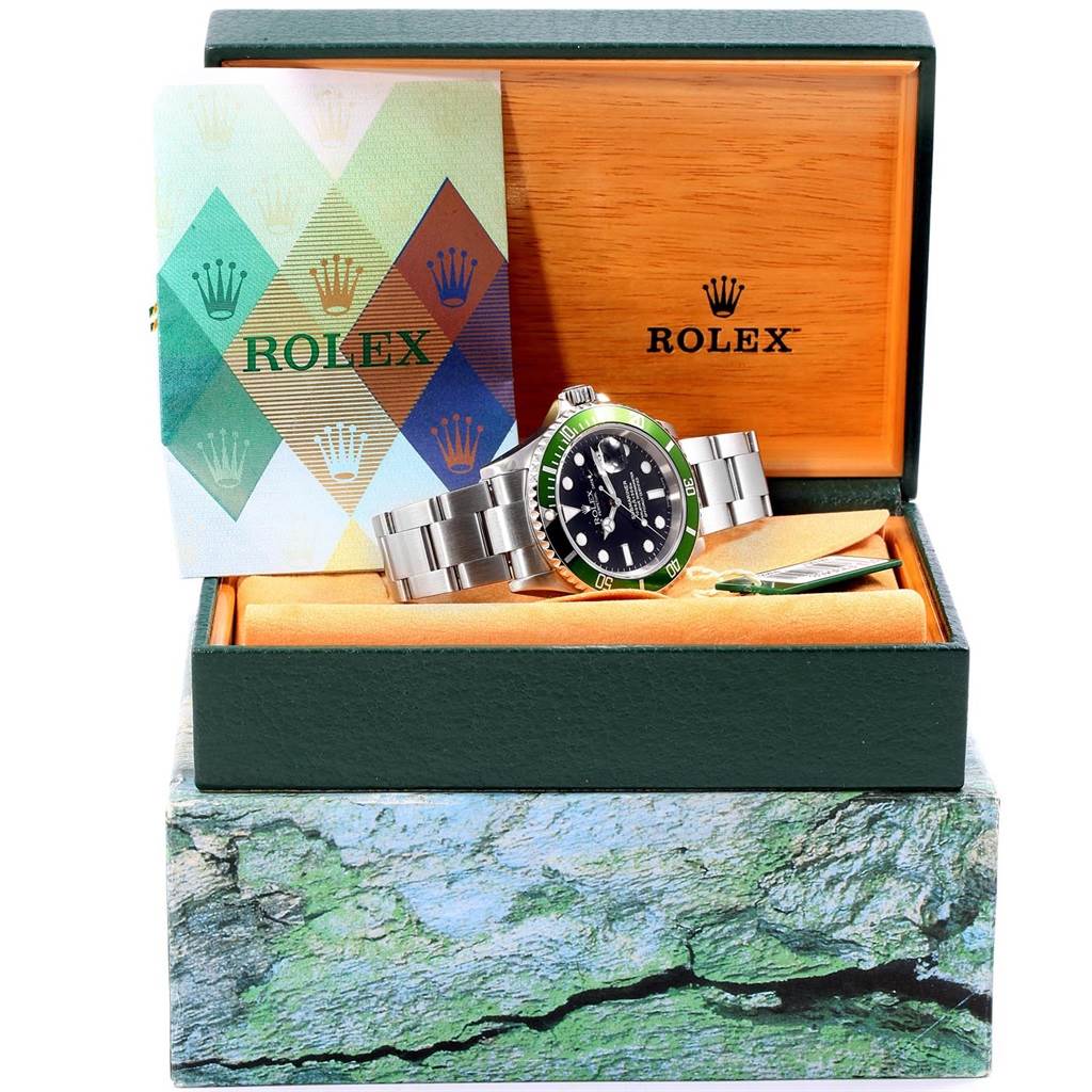 This image shows a Rolex Submariner 16610LV Men
s Stainless Steel Black Dial 16610LV Men
s Stainless Steel Black Dial watch at an angle with its packaging, displaying the watch, box, and certification booklet.