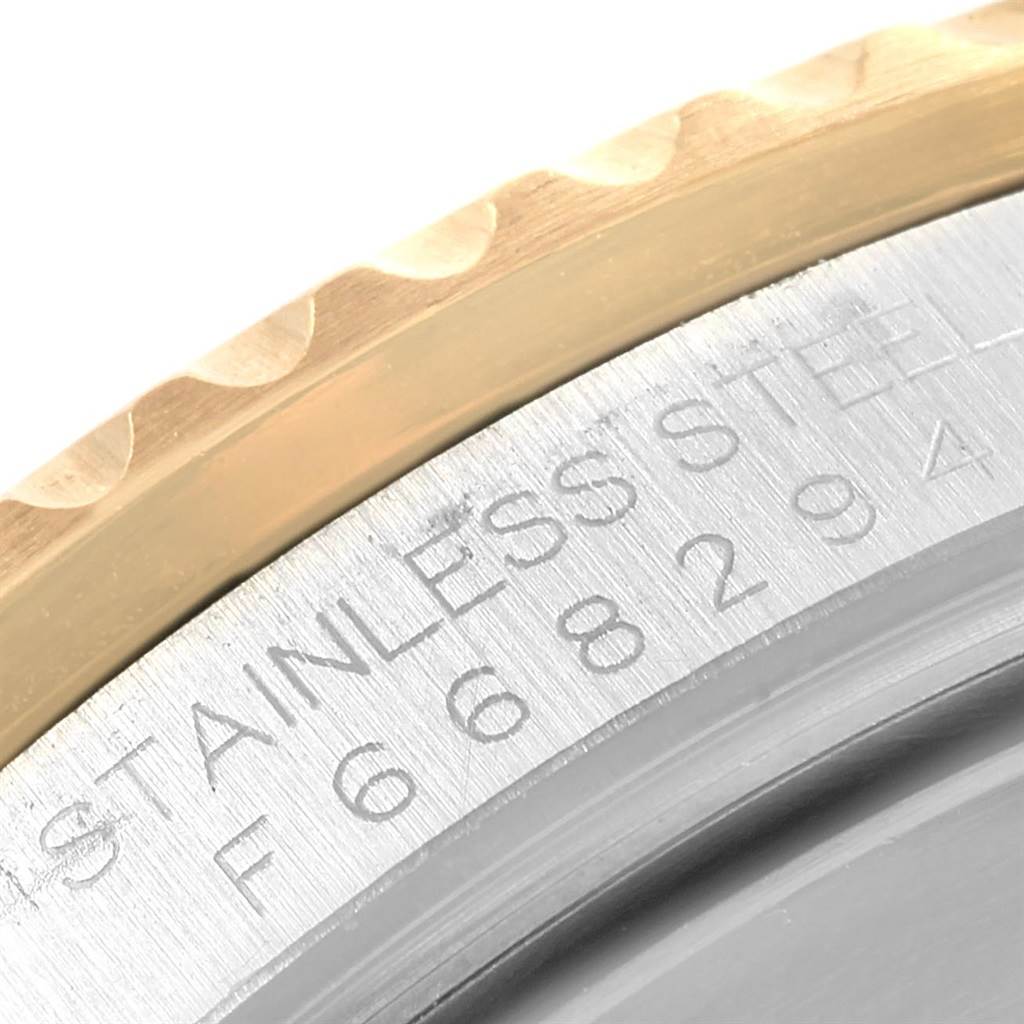 The image shows a close-up of the edge and stainless steel case with visible serial number of a Rolex Submariner 16613 Men
s Steel and Gold (two tone) Grey Dial 16613 Men
s Steel and Gold (two tone) Grey Dial watch.