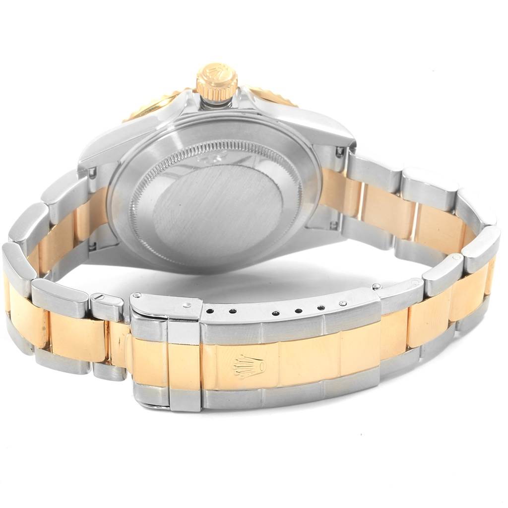 The image shows the back view of a Rolex Submariner 16613 Men
s Steel and Gold (two tone) Grey Dial 16613 Men
s Steel and Gold (two tone) Grey Dial, highlighting its two-tone strap, clasp, and case back.