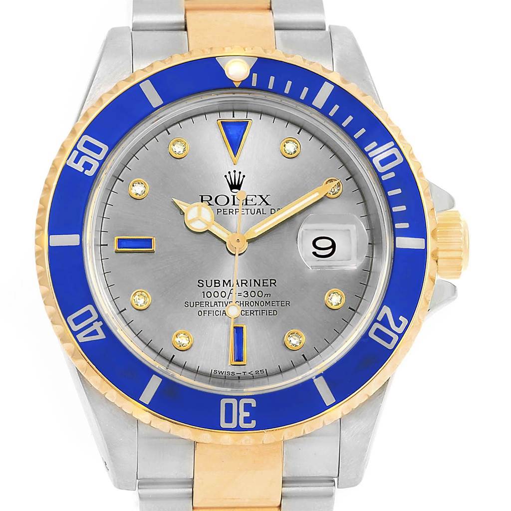 The image shows a front view of a Rolex Submariner 16613 Men
s Steel and Gold (two tone) Grey Dial 16613 Men
s Steel and Gold (two tone) Grey Dial with a blue and gold bezel, silver dial, date window, and two-tone bracelet.