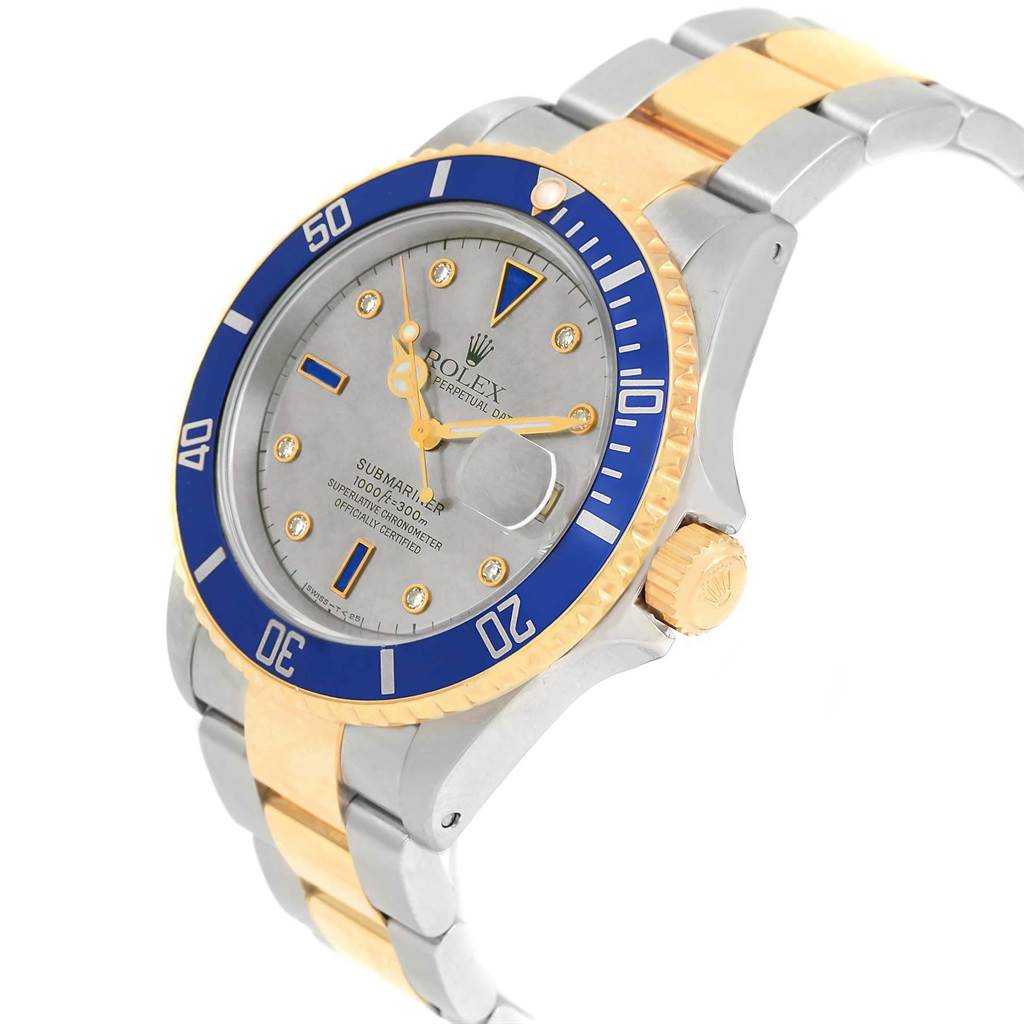 The Rolex Submariner 16613 Men
s Steel and Gold (two tone) Grey Dial 16613 Men
s Steel and Gold (two tone) Grey Dial watch is shown at a slight angle, highlighting the blue bezel, dial, crown, and part of the bracelet.