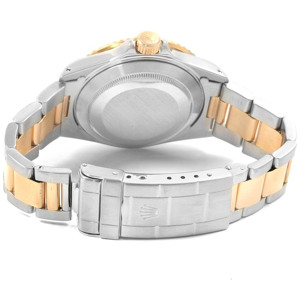 The image shows the back case and two-tone bracelet of a Rolex Submariner 16613 Men
s Steel and Gold (two tone) Grey Dial 16613 Men
s Steel and Gold (two tone) Grey Dial watch, with its clasp and crown visible.