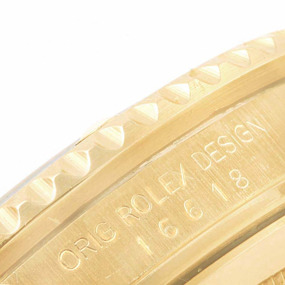 This close-up image shows the engraved edge of the bezel and case of a Rolex Submariner 16618 Men's Yellow Gold Purple Dial 16618 Men's Yellow Gold Purple Dial watch.