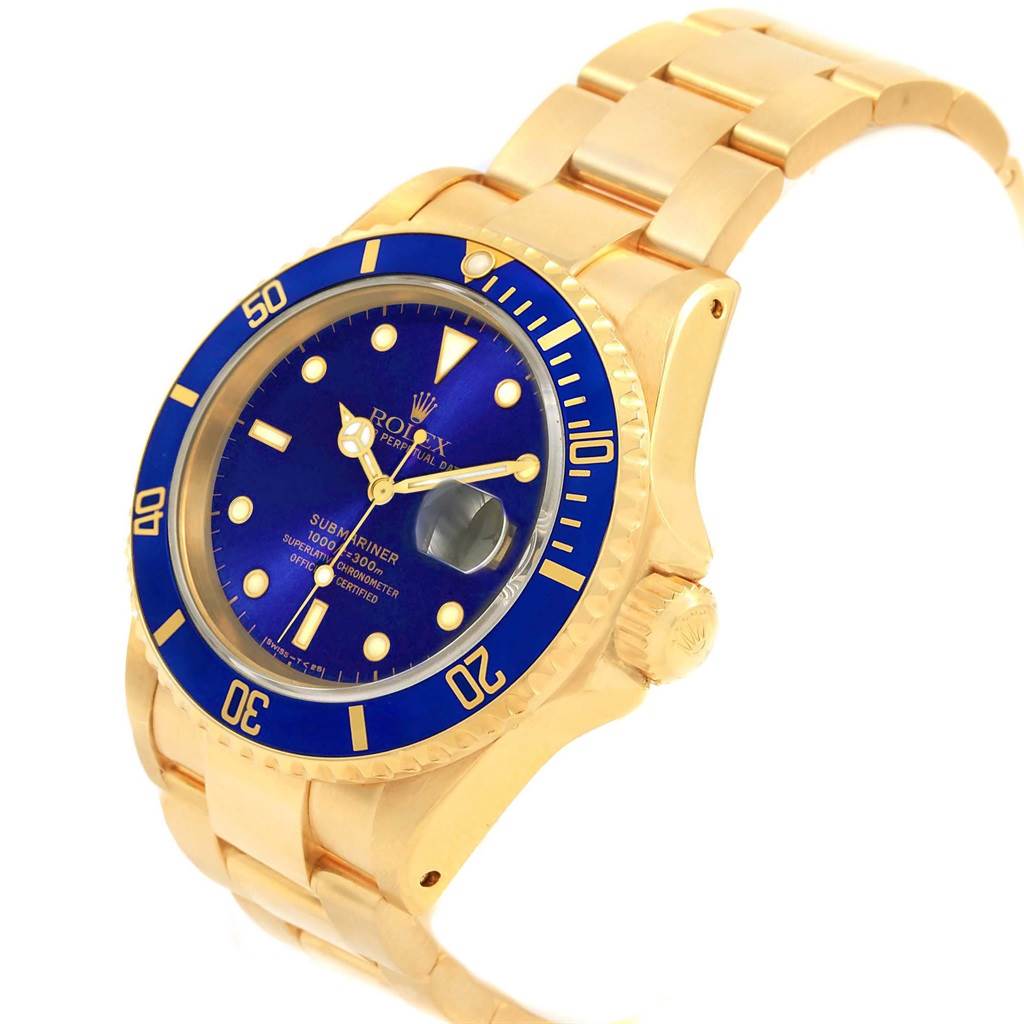 This Rolex Submariner 16618 Men's Yellow Gold Purple Dial 16618 Men's Yellow Gold Purple Dial watch is shown at a slight angle, displaying its gold case, blue dial, blue bezel, and gold bracelet.