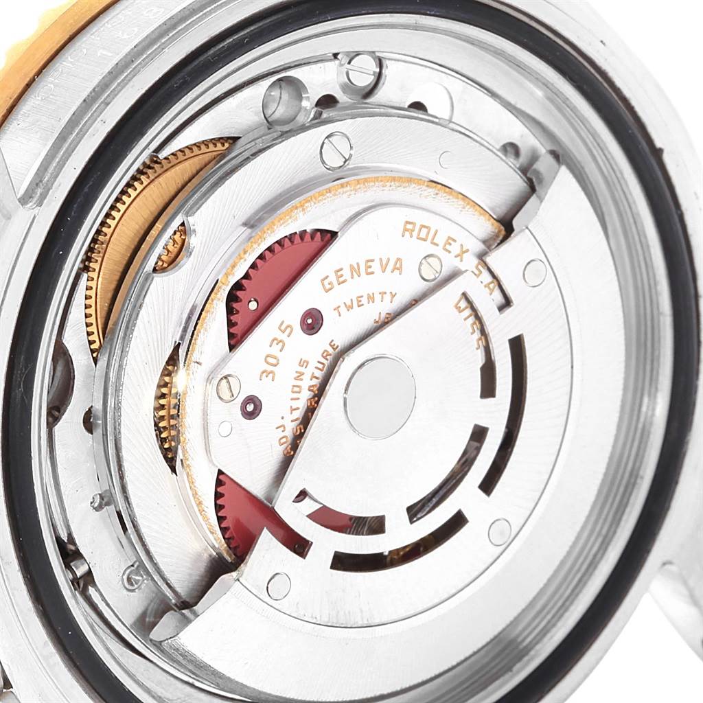 The image shows a close-up view of the movement inside a Rolex Submariner 16803 Men's Steel and Gold (two tone) Blue Dial 16803 Men's Steel and Gold (two tone) Blue Dial watch, including gears and the rotor.