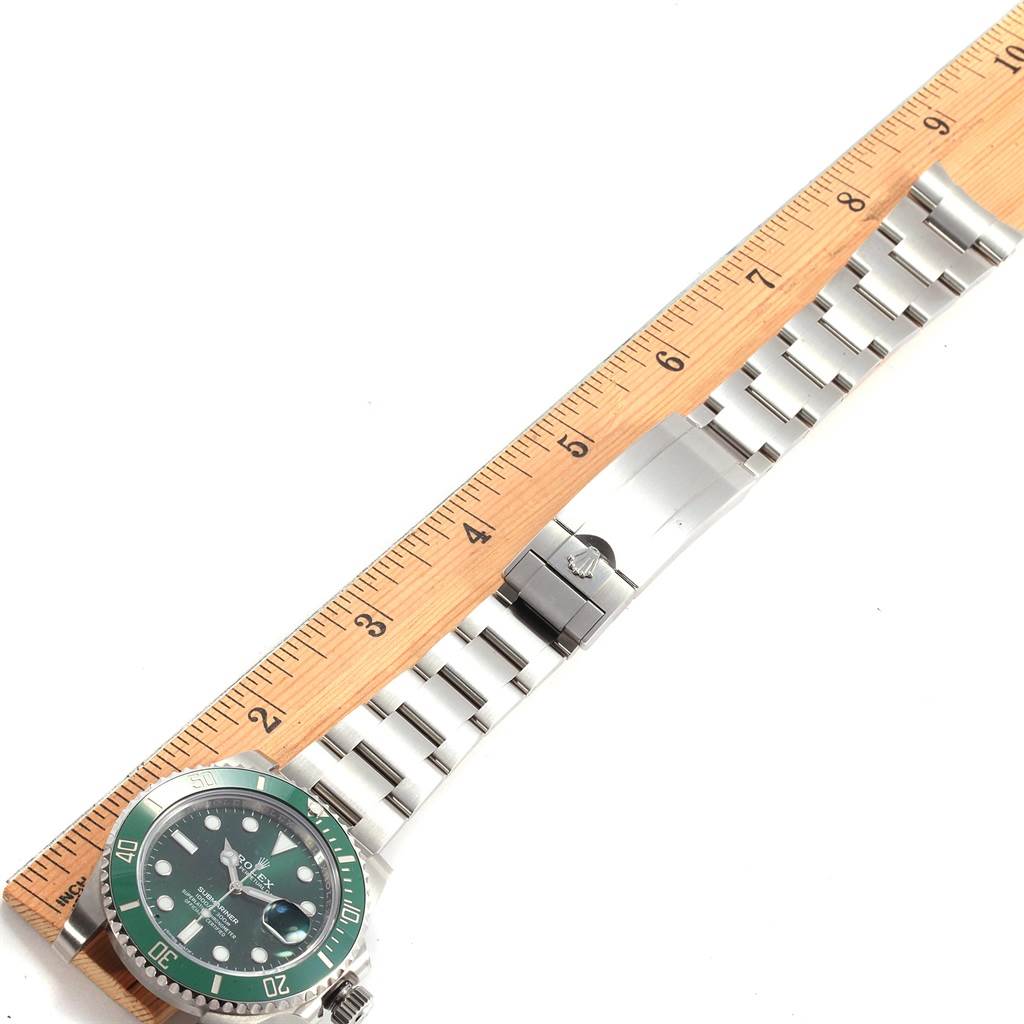 The image shows a Rolex Submariner 16610LV Men's Stainless Steel Green Dial 16610LV Men's Stainless Steel Green Dial watch laid out alongside a ruler, displaying the face, bezel, and bracelet.