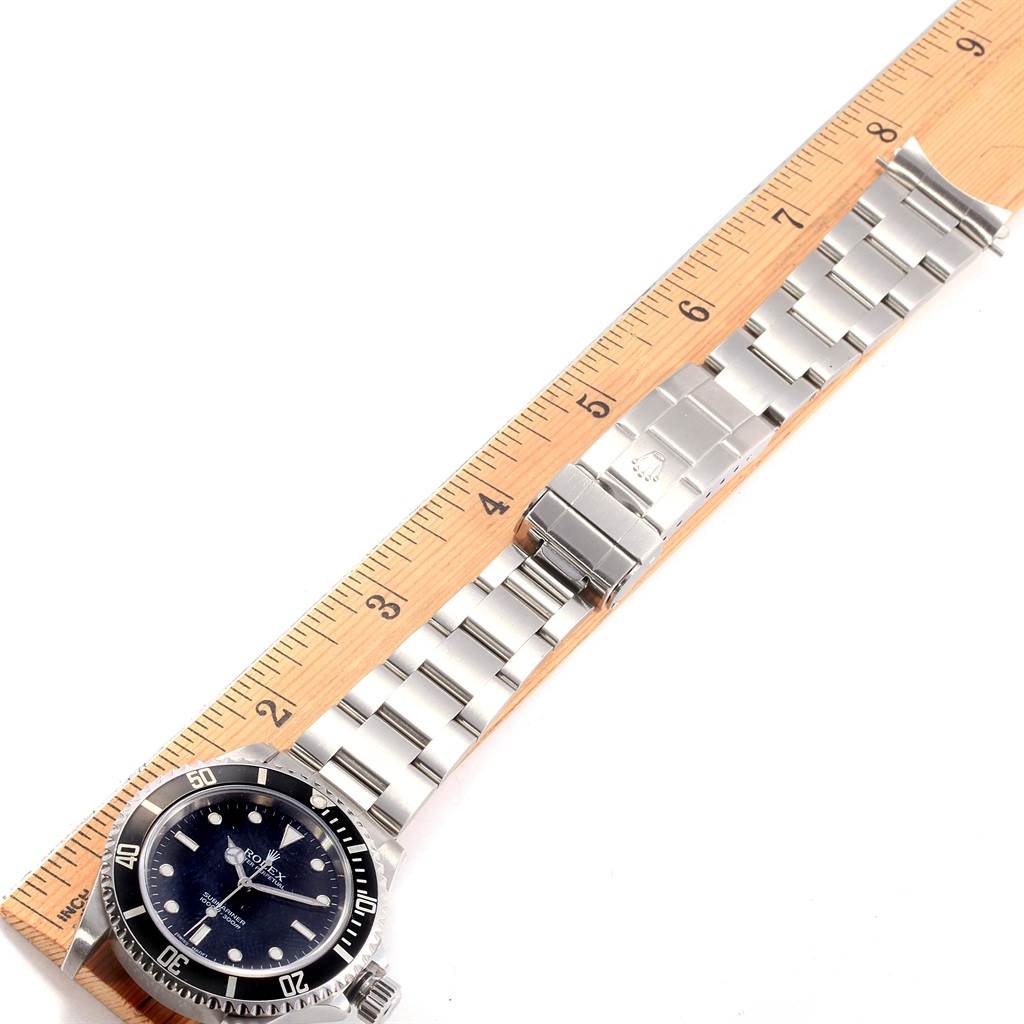 The image shows the full length of a Rolex Submariner 14060 Men
s Stainless Steel Black Dial 14060 Men
s Stainless Steel Black Dial watch and its bracelet, placed next to a ruler for scaling.