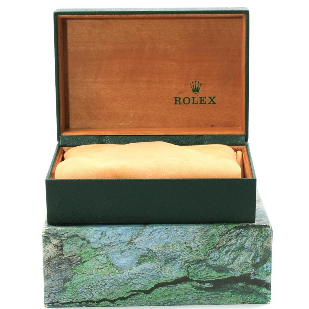 The image shows an open green Rolex box with a cushion inside, likely for a Submariner model watch.