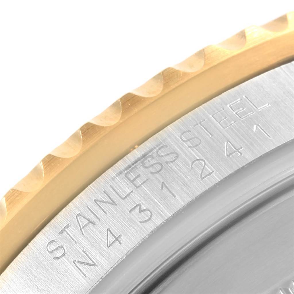 The image shows a close-up of the edge and engraved text on the bezel and case back of a Rolex Submariner 16613 Men's Steel and Gold (two tone) Black Dial 16613 Men's Steel and Gold (two tone) Black Dial watch.