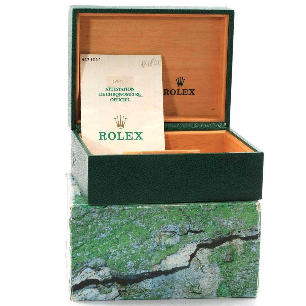 The image shows an open green Rolex box and a manual for the Rolex Submariner 16613 Men's Steel and Gold (two tone) Black Dial 16613 Men's Steel and Gold (two tone) Black Dial model, showcasing the exterior and interior packaging.