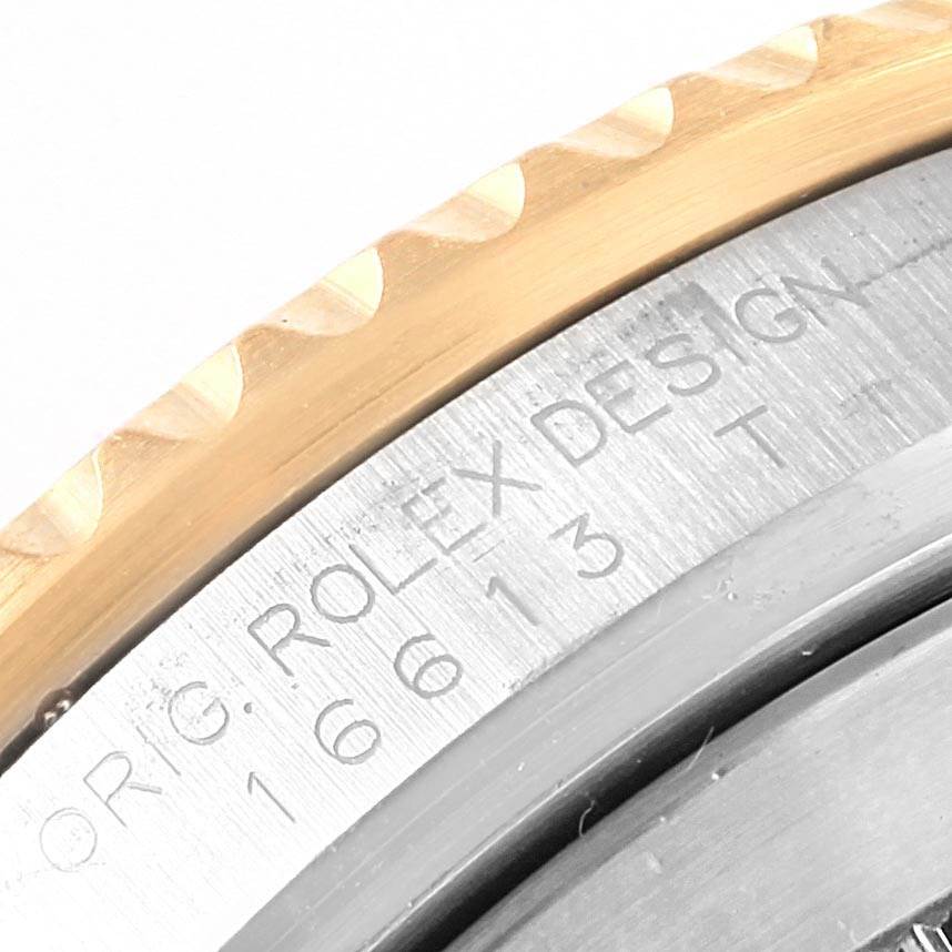 This close-up image shows the edge of the case and the engraved design details on a Rolex Submariner 16613 Men's Steel and Gold (two tone) Black Dial 16613 Men's Steel and Gold (two tone) Black Dial model.
