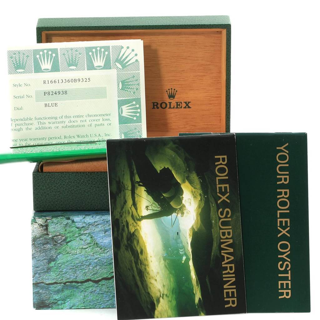 The image shows a Rolex Submariner 16613 Men
s Steel and Gold (two tone) Blue Dial 16613 Men
s Steel and Gold (two tone) Blue Dial
s box, warranty card, and manuals, viewed from the front.