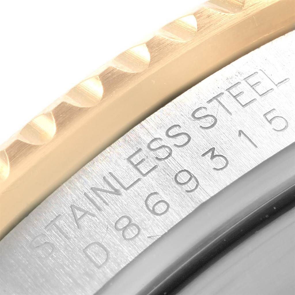 This close-up photo shows the bezel and part of the case back of a Rolex Submariner 16613 Men's Steel and Gold (two tone) Black Dial 16613 Men's Steel and Gold (two tone) Black Dial watch, highlighting the stainless steel engraving.