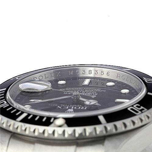 This is an angled close-up of the bezel, dial, and part of the bracelet of a Rolex Submariner 16610 Men's Stainless Steel Black Dial 16610 Men's Stainless Steel Black Dial watch.