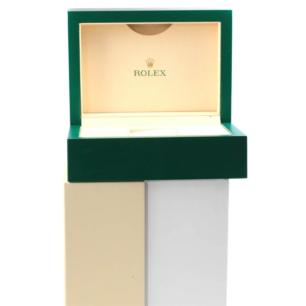 The image shows an open green and beige Rolex box for the Submariner model, displaying the inside with the brand
s logo.