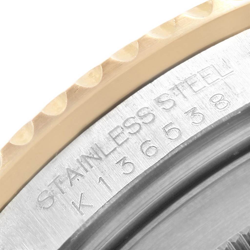 The image shows a close-up view of the case back and bezel of a Rolex Submariner 16613 Men's Steel and Gold (two tone) Black Dial 16613 Men's Steel and Gold (two tone) Black Dial watch, highlighting its stainless steel material and engravings.